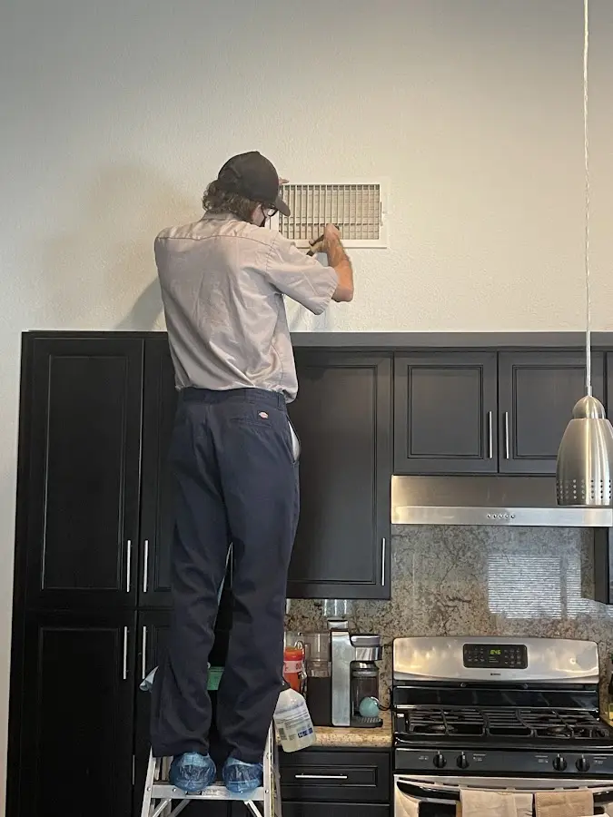 Technician inspecting an air vent during HVAC service in Bluefield
